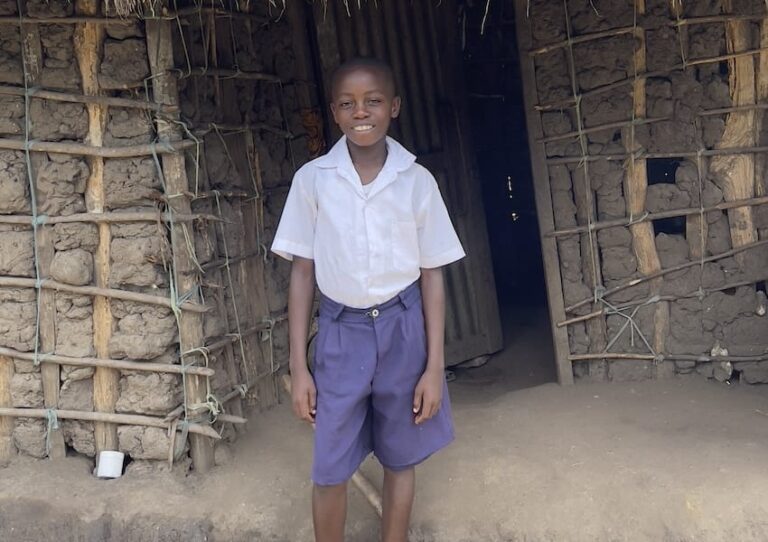 Un niño frente a una casa en África