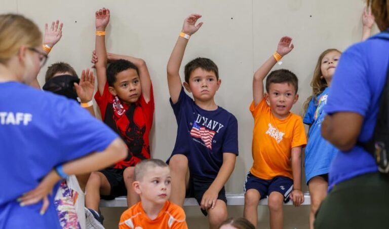 Un grupo de niños levantando la mano